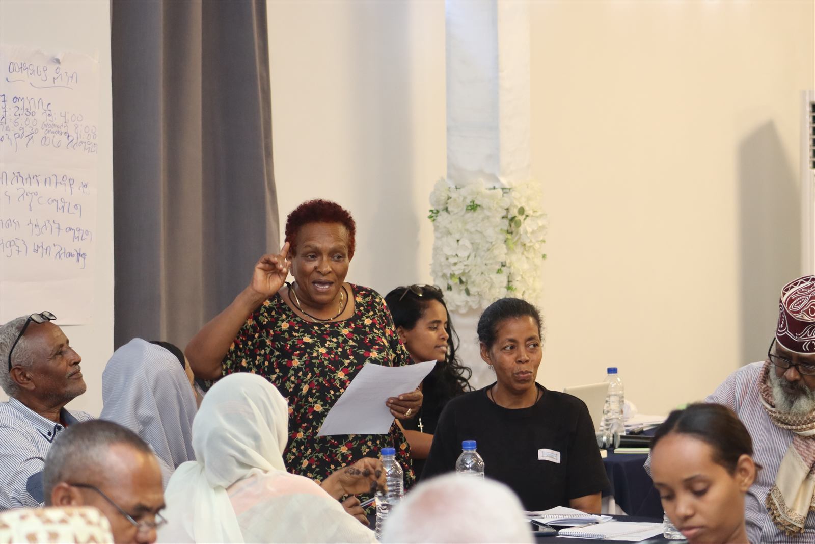 A participant raising a hand while speaking during an open discussion
