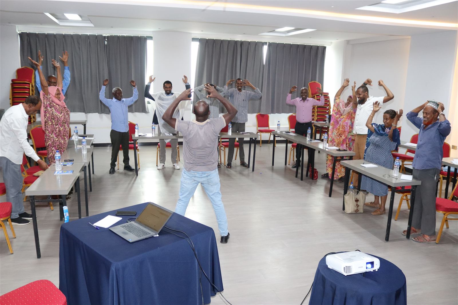 Participants stretching during an energizer break, arms raised