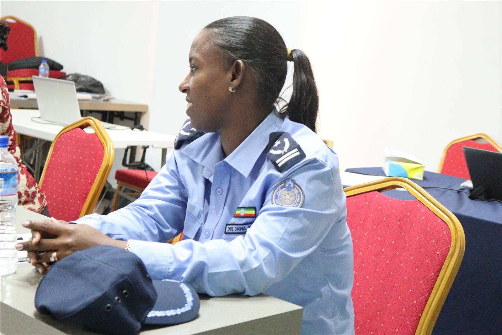 A Dire Dawa police officer seated at the workshop table alongside community participants