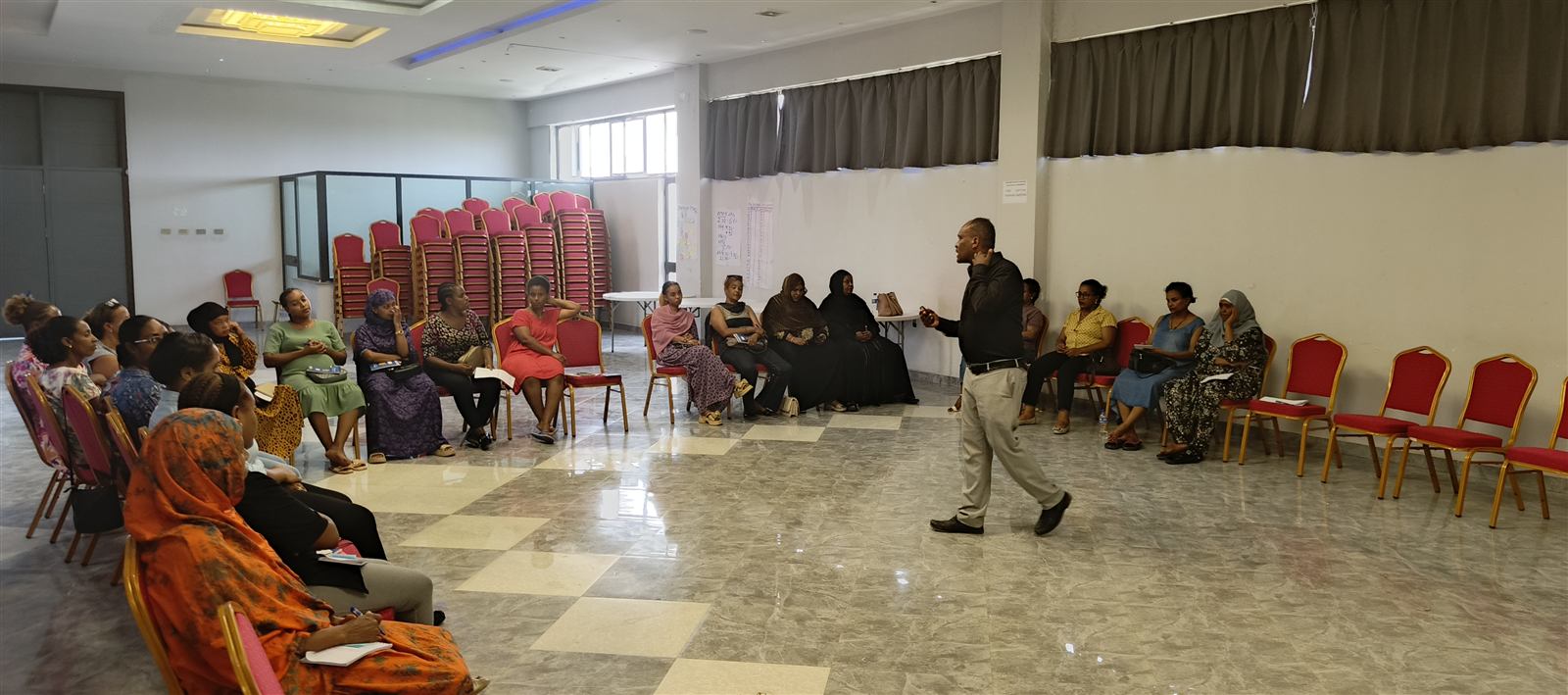 Facilitator speaking to a full circle of seated women in the afternoon session